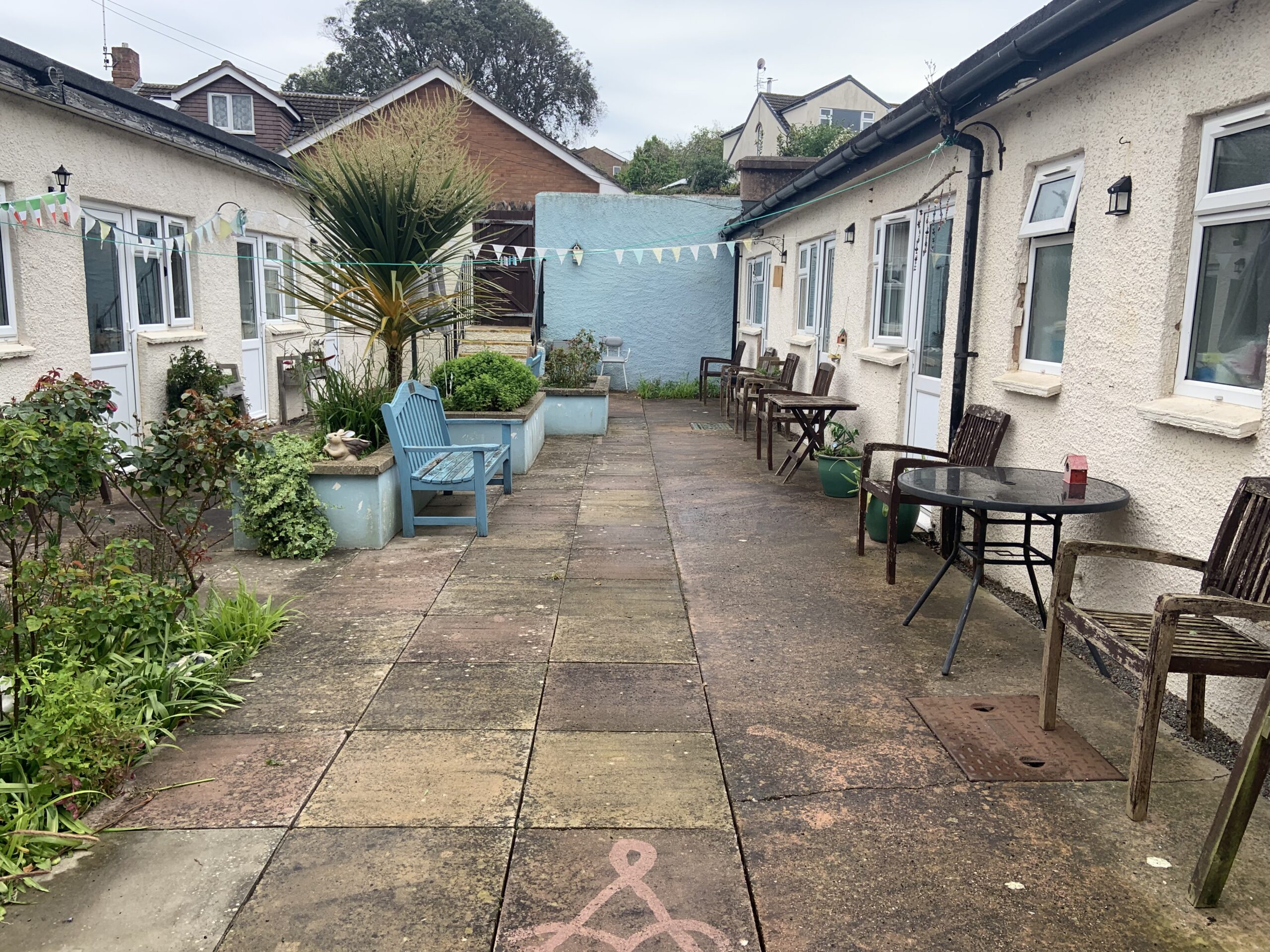 Ashfield garden with planted beds and benches from opposite end