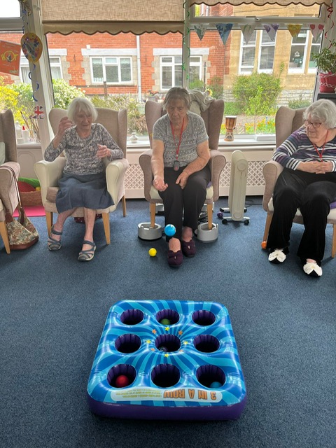Barb throwing a ball at a 3x3 hole blow-up mat