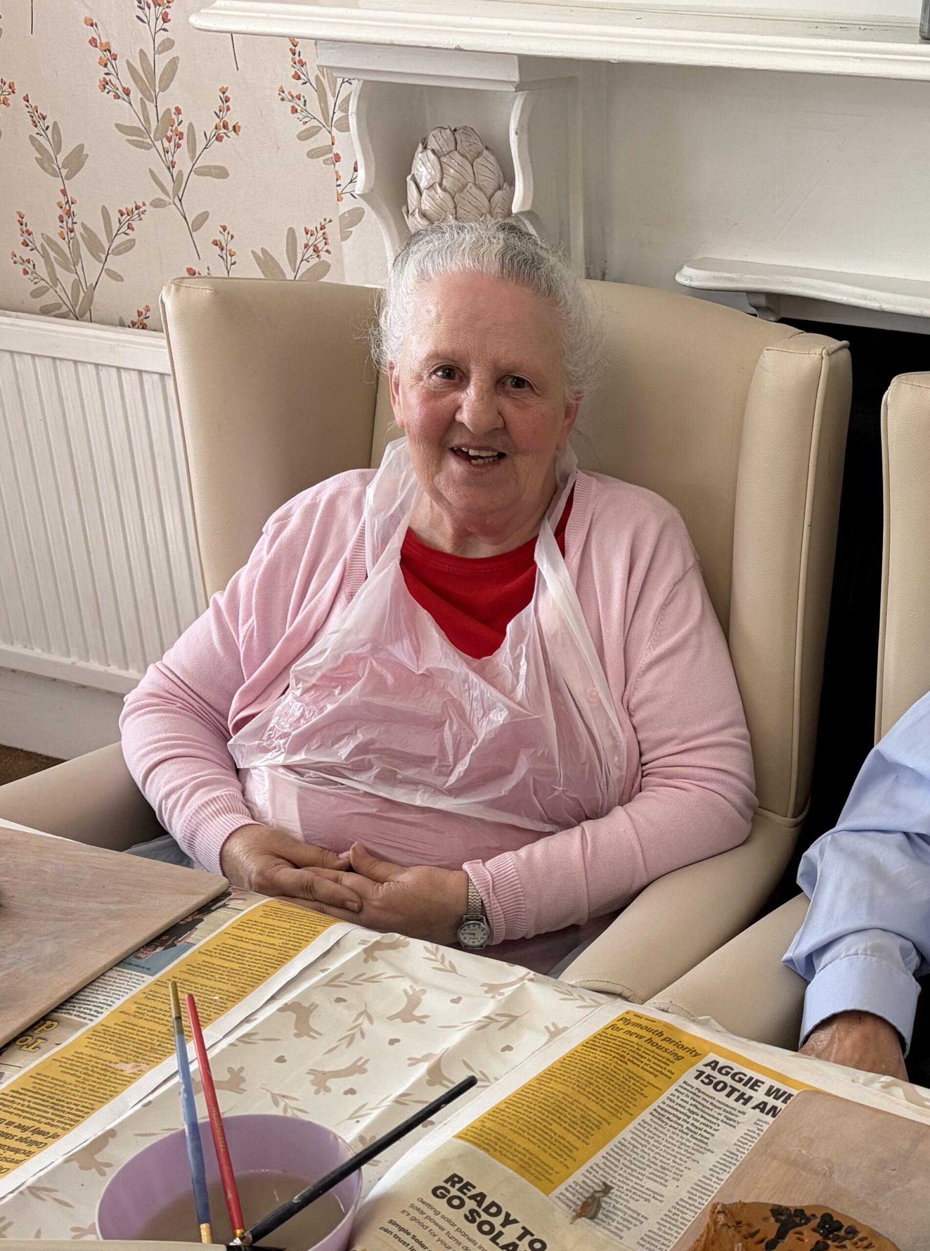 Female resident seated at the table smiling at the camera