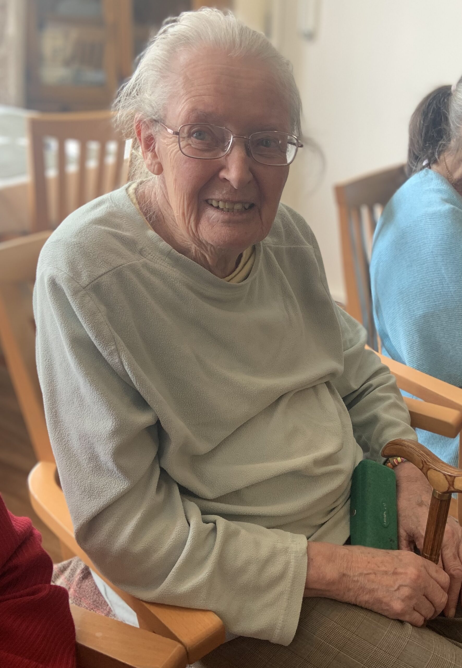 Female resident seated smiling for a photo