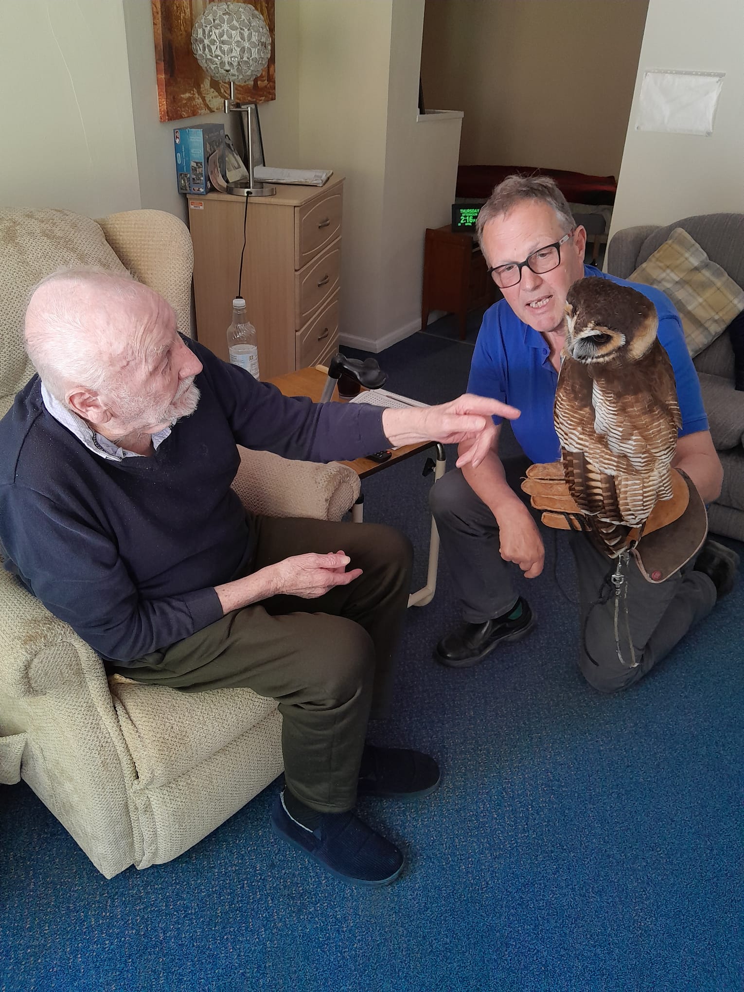 Ivor seated whilst stroking Bill the Owl's chest
