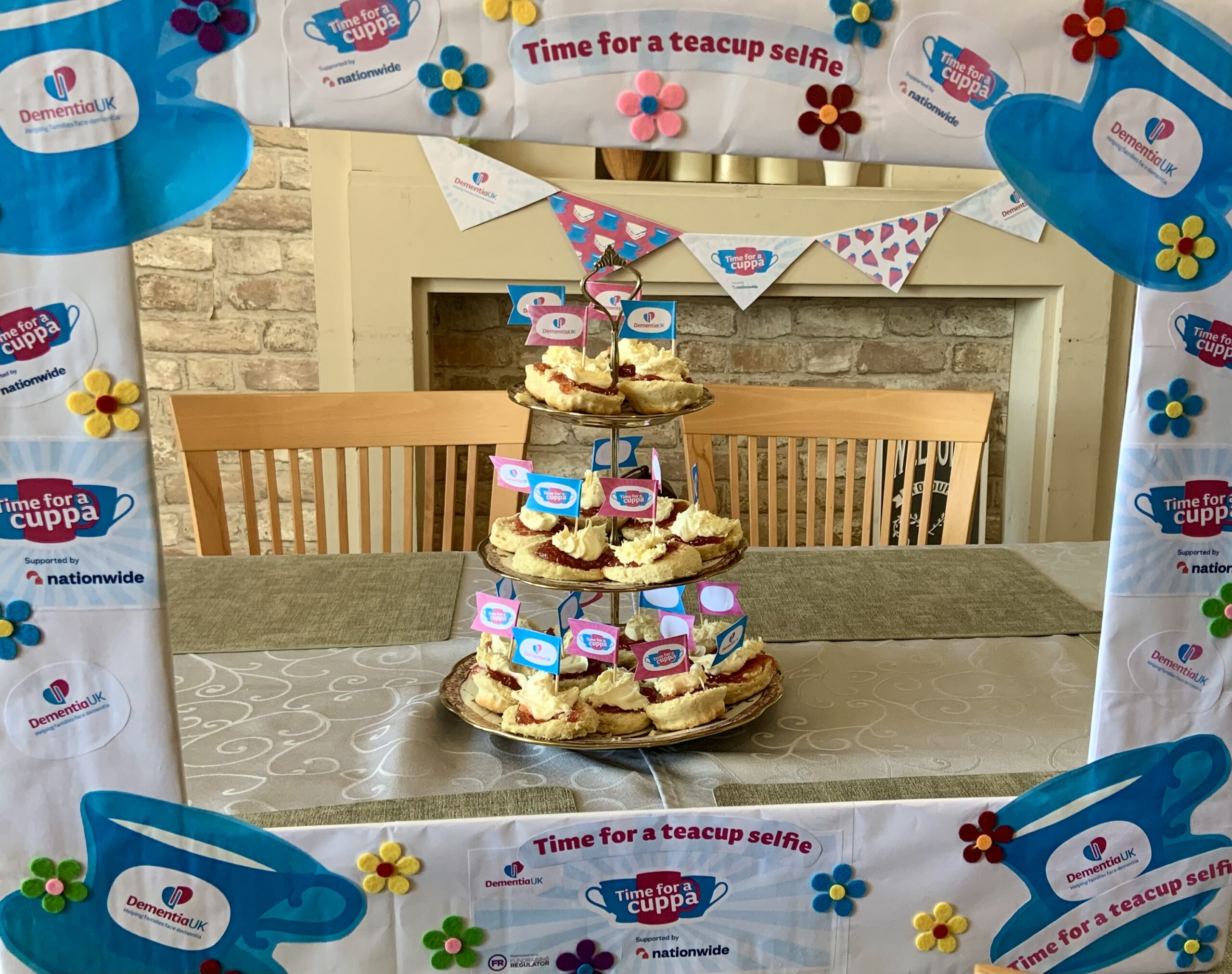 Jam and cream scones arranged on a 3-tier cake stand with Time for a Cuppa picture frame