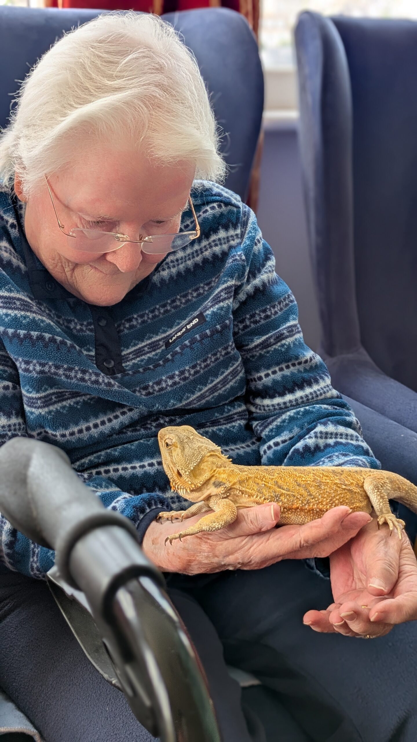 Lyn holding a bearded dragon smiling at it