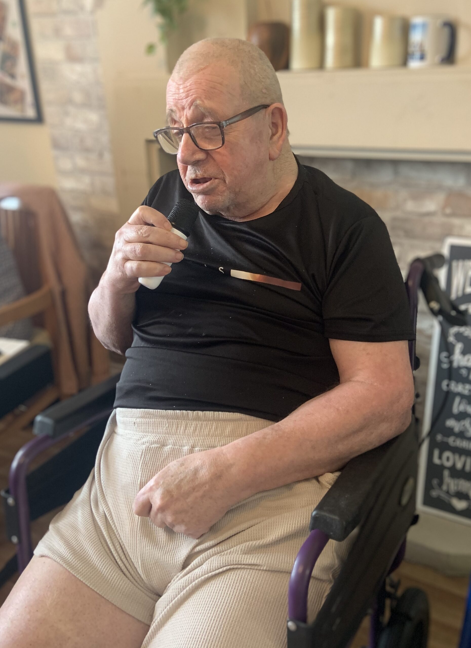 Male resident singing into a microphone
