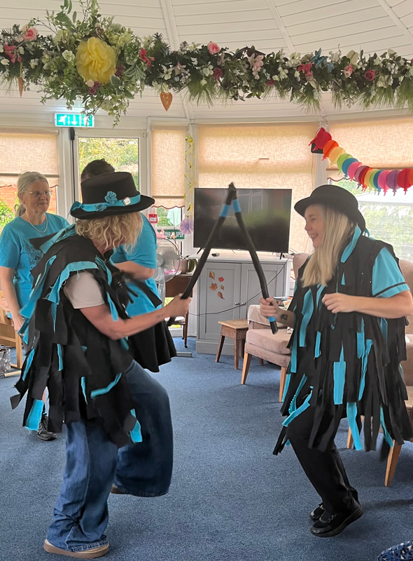 Morris dancers dancing, banging their sticks