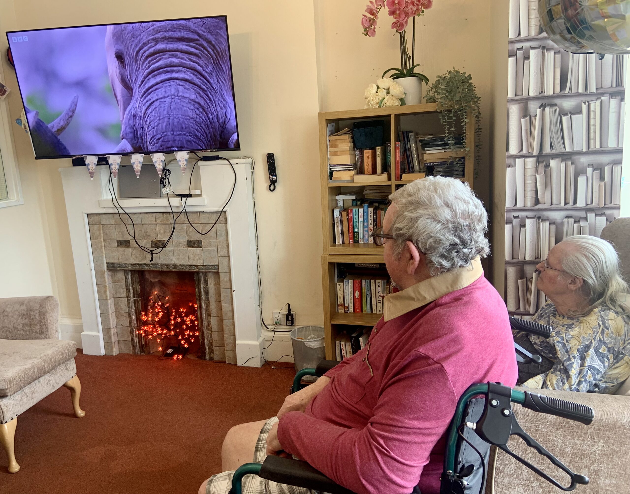 Residents seated around a screen showing an episode of Our Planet