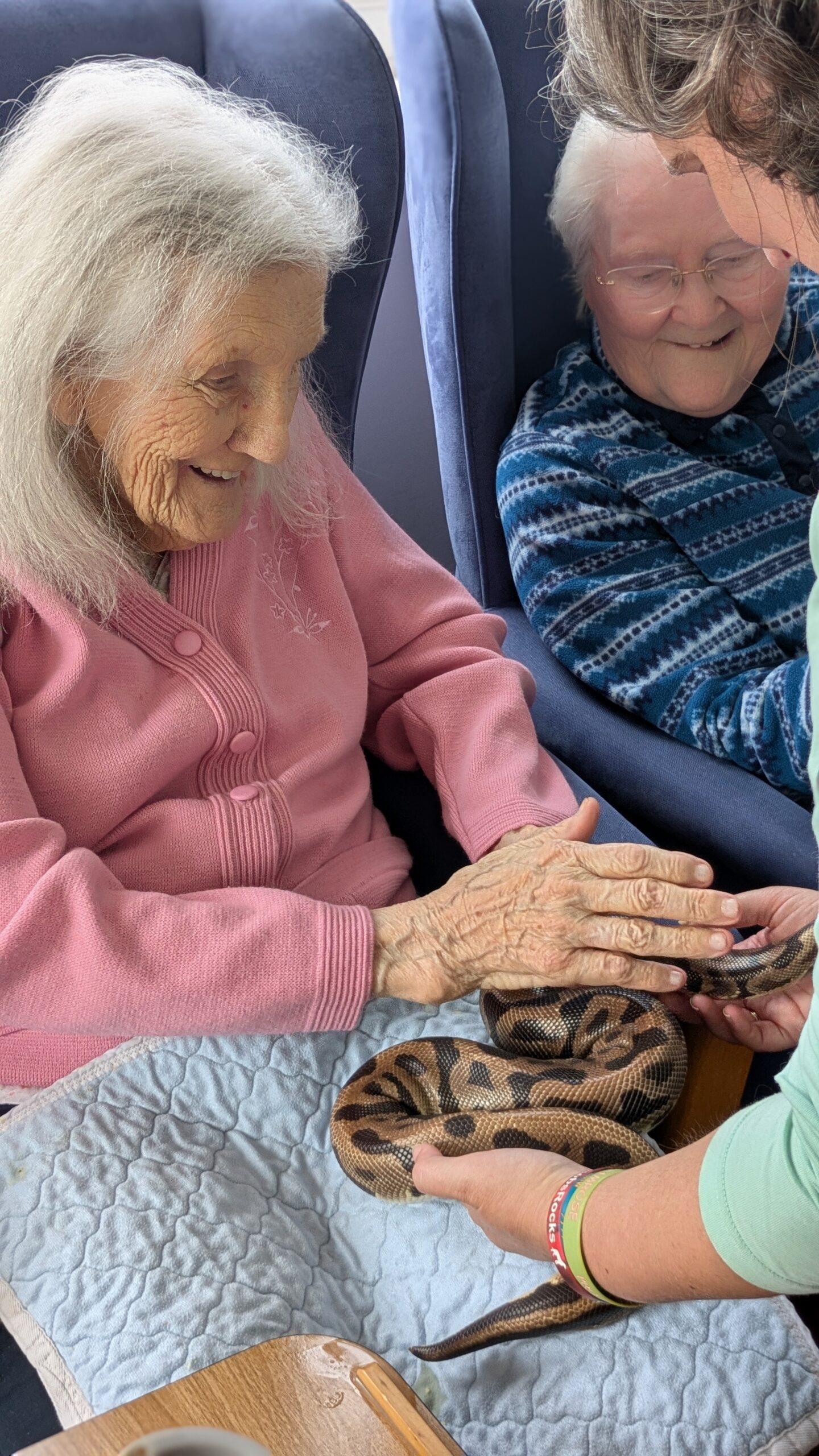 Ruth stroking a python smiling