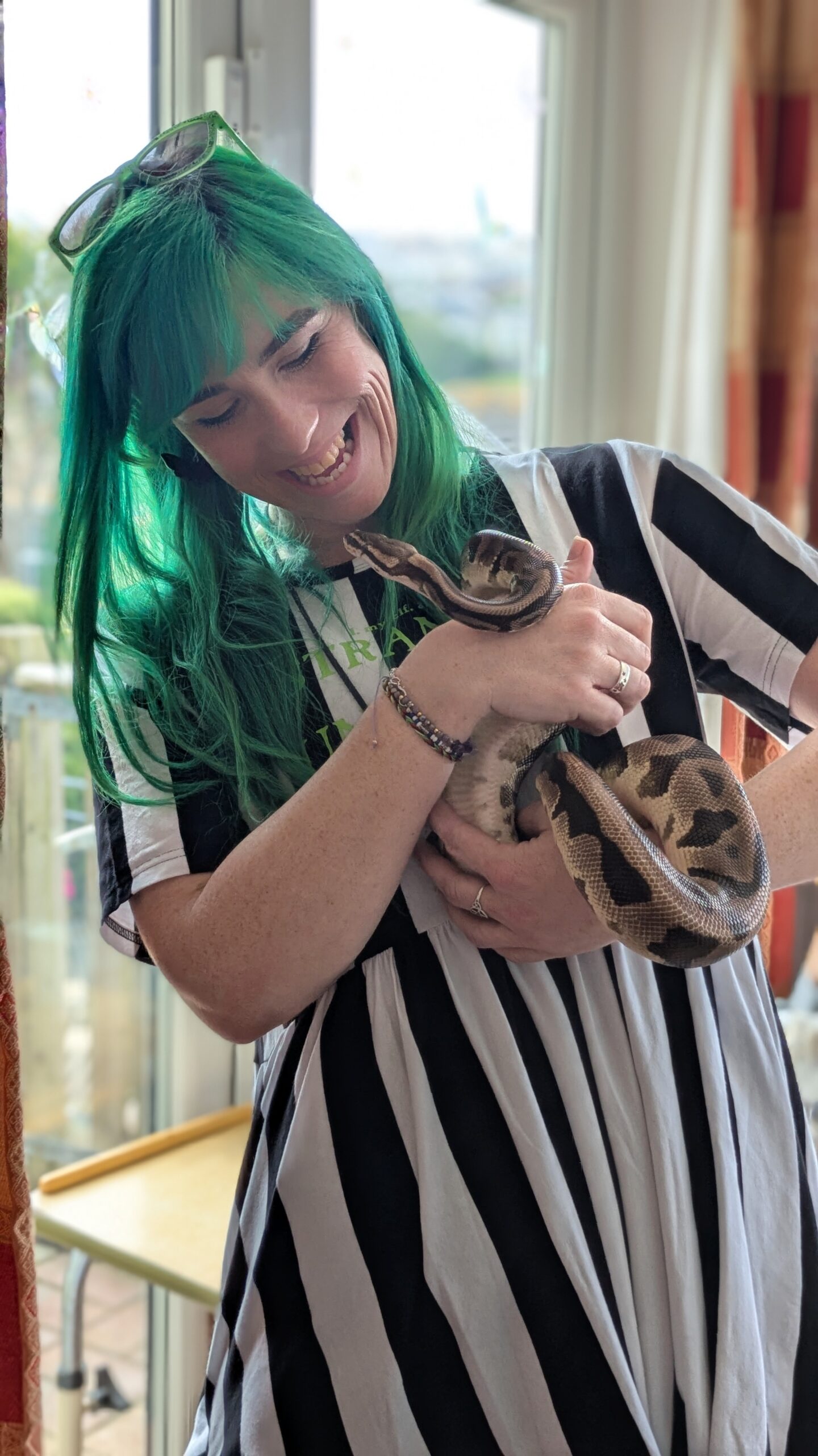 Staff member Jess holding and looking st the face of a python