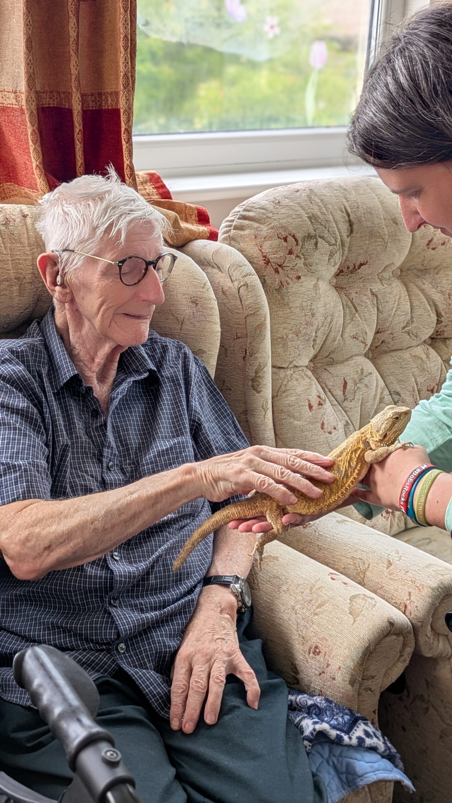 Terry stoking a bearded dragon smiling