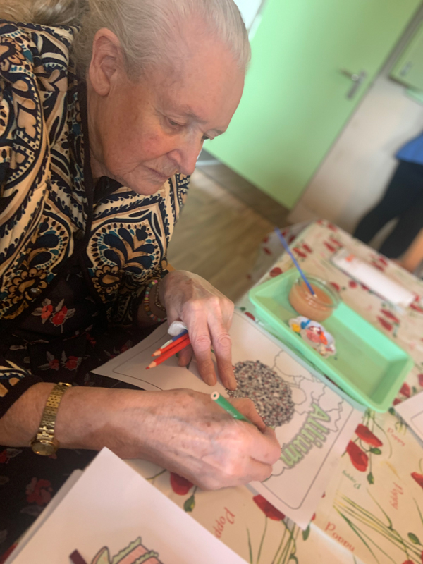 Female resident using colour pencils on an image Allium